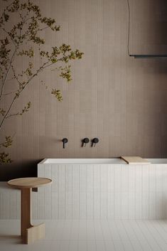 a white bath tub sitting next to a wooden table in a room with wallpaper