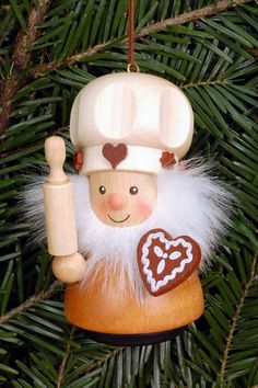 a christmas ornament hanging from a tree with a pastry and heart on it