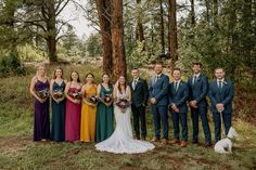 a group of people standing next to each other in front of a tree with a dog