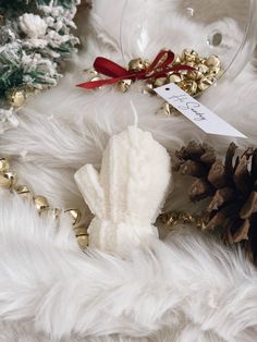 a pine cone is on the fur next to a christmas ornament and other decorations