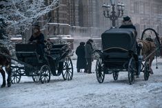 a horse drawn carriage traveling down a snow covered street