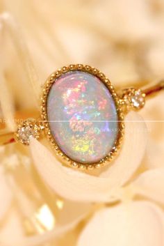 This stunning shimmery stone is opal. This opal ring can go with every outfit #opalring #gemstonering #engagementring #goldring Spiritual Yellow Gold Oval Opal Ring, Heirloom Gold Opal Gemstone Ring, Gold Opal Ring Fine Jewelry, Gold Opal Ring With Spiritual Style, Gold Halo Jewelry For Marriage, Heirloom Opal Rings In Gold, Gold Opal Ring With Halo Design - Gift, Gold Opal Ring With Halo Design, Oval Shape, Gold Opal Ring With Halo Design In Oval Shape