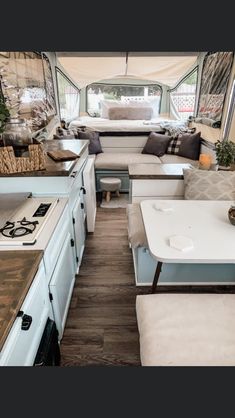 the inside of a camper with couches, tables and kitchenette in it