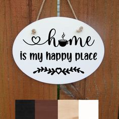 a sign that says home is my happy place hanging on the side of a wooden fence