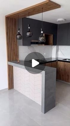 a kitchen with black cabinets and white countertops in an open floor plan that has wood accents on the walls