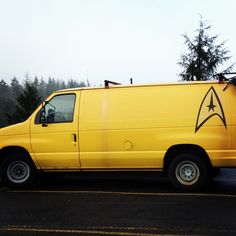 a yellow van with a star trek symbol painted on the side