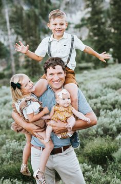 a man holding two children in his arms