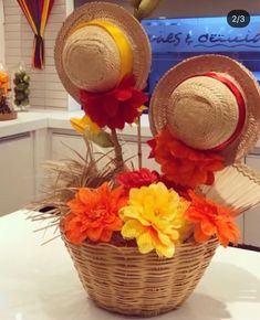 two hats sitting on top of a basket filled with flowers