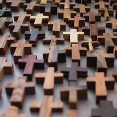 many wooden crosses are arranged together on the floor, as if they were made out of wood