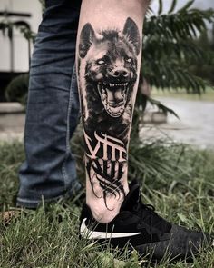 a man's leg with a tattoo on it that has a wolf and the word city