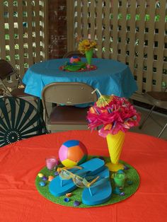 the table is set up for an outdoor birthday party with balloons and toys on it