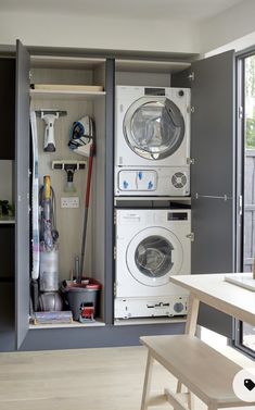 a washer and dryer are in an open cabinet next to the kitchen table