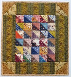 a quilted wall hanging with many different colors