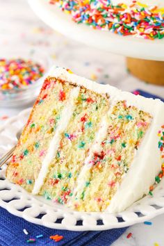 a slice of cake with white frosting and sprinkles