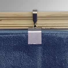 a blue towel hanging on the side of a wooden door with a silver square in it