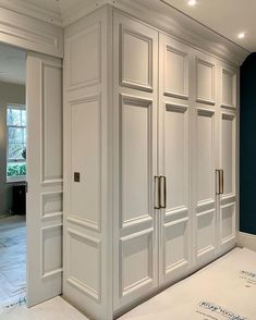 an empty room with white cabinets and blue walls in the background is being renovated by someone