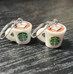 two starbucks mugs with key chains attached to them