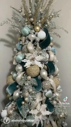 a christmas tree decorated with silver, white and gold ornaments