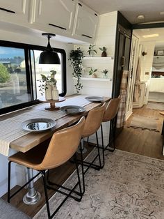 a dining table with four chairs in front of a window