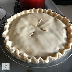 an uncooked pie sitting on top of a stove next to a red candle