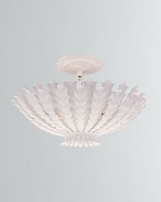 a white light fixture hanging from the ceiling in a room with gray walls and flooring