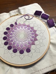 an embroidery project with purple and white designs