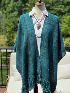 a woman's green shawl with fringes on it and a white shirt