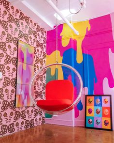 a room with colorful wallpaper and a hanging chair in the middle of the room