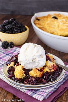 a plate with a scoop of ice cream on top of it next to a bowl of berries