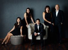 a group of people sitting on top of a couch in front of a black wall