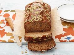 there is a loaf of bread with seeds on it next to a plate and napkin