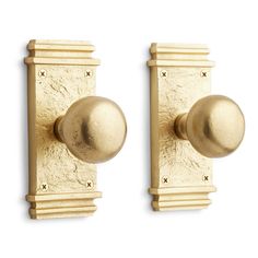 two golden door knobs on a white background