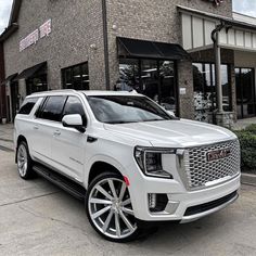 a white suv parked in front of a building