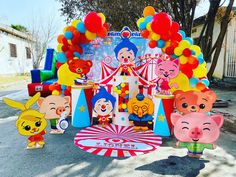 an amusement park with balloons and cartoon characters on the ground, as well as other decorations