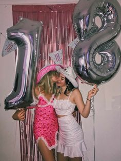 two young women are posing for a photo with balloons and the number eight on it