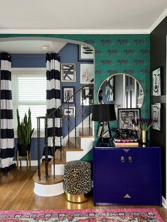 a living room filled with furniture and walls covered in black and white striped wallpaper