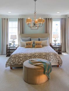 a bedroom with a large bed and chandelier hanging from it's ceiling