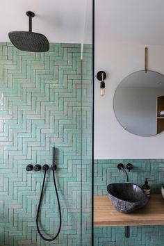 a bathroom with green tiles and black fixtures