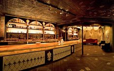 a dimly lit bar with lots of bottles on the shelves