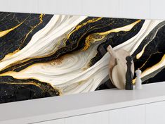 a black and white marble wallpaper with gold swirls on it's sides