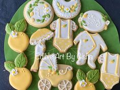 baby shower cookies are arranged on a green platter with white and yellow icing