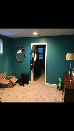 an empty room with blue walls and white carpet