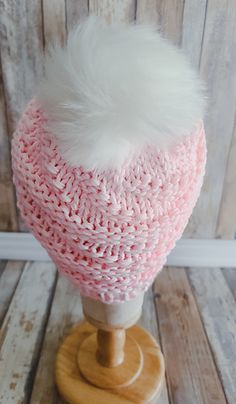 a pink hat with white fur on top