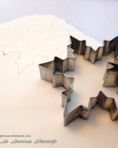 several cookie cutters shaped like snowflakes on top of a white countertop