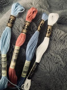 three skeins of yarn sitting on top of a fur covered floor next to each other