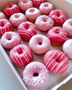 a box filled with lots of pink and white donuts