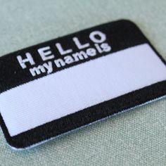 a black and white name tag with the word hello my name is written on it