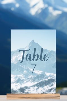 This beautiful mountain wedding table number features a powerful photograph of snow capped mountains in the winter. Customize in blue script over the snowy hills. Perfect photography decor for a cold weather wedding. #winterwedding #mountainwedding