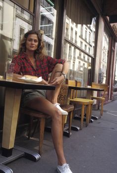 a woman sitting at a table with her legs crossed