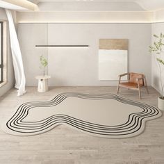 a white room with a black and white rug on the floor next to a chair